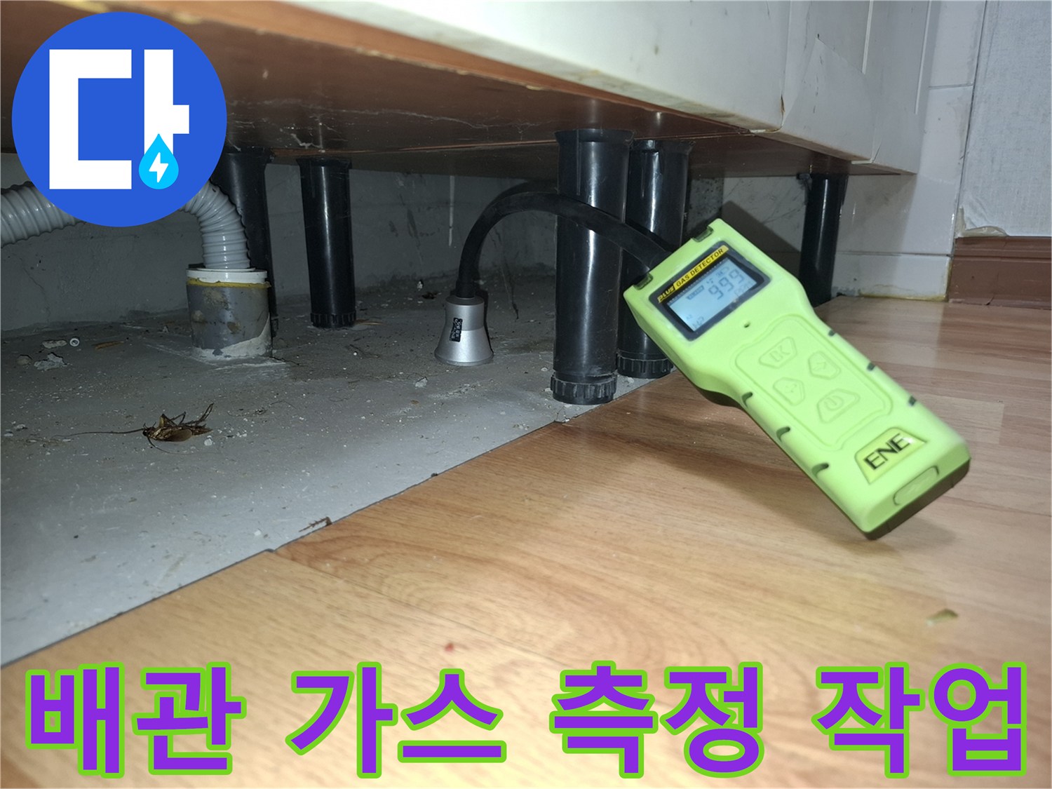 싱크대 하부 배관 사이로 가스 탐지 센서를 대고 있는 모습