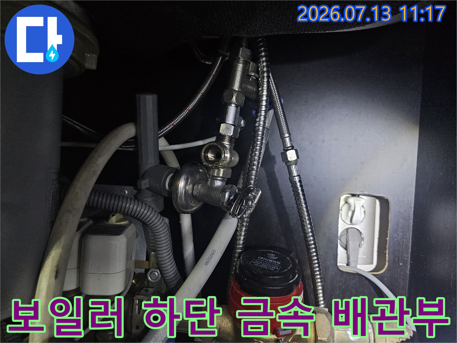 은색의 유연한 주름관과 빨간색 조절 밸브가 설치된 보일러 하단-사진