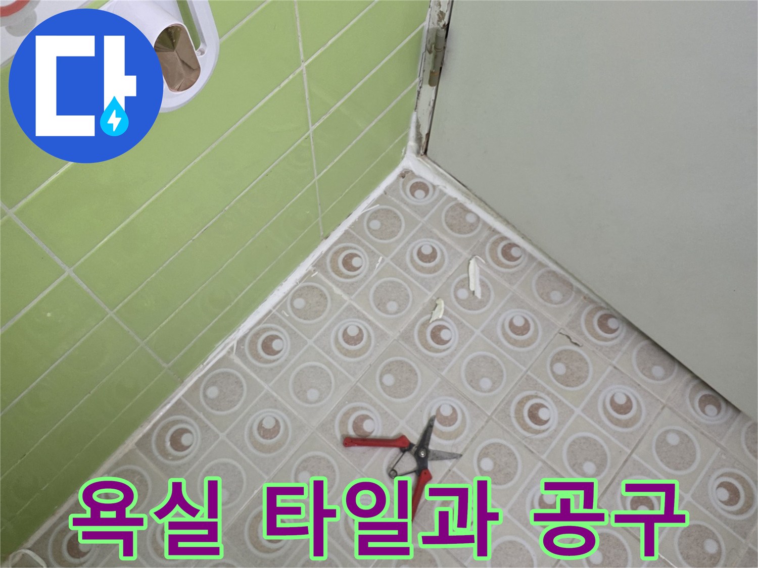 연두색 욕실 타일 위로 놓인 빨간색 니퍼와 도구들