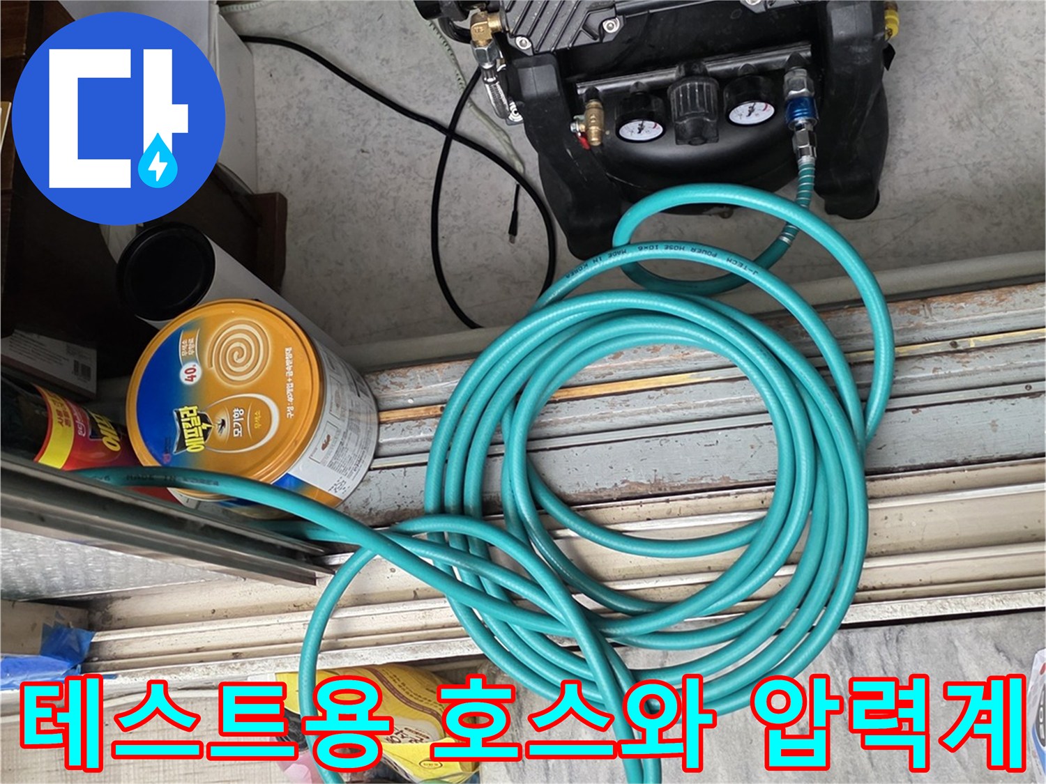 바닥의 파란색 호스와 검정색 공압 테스트 장비 세팅
