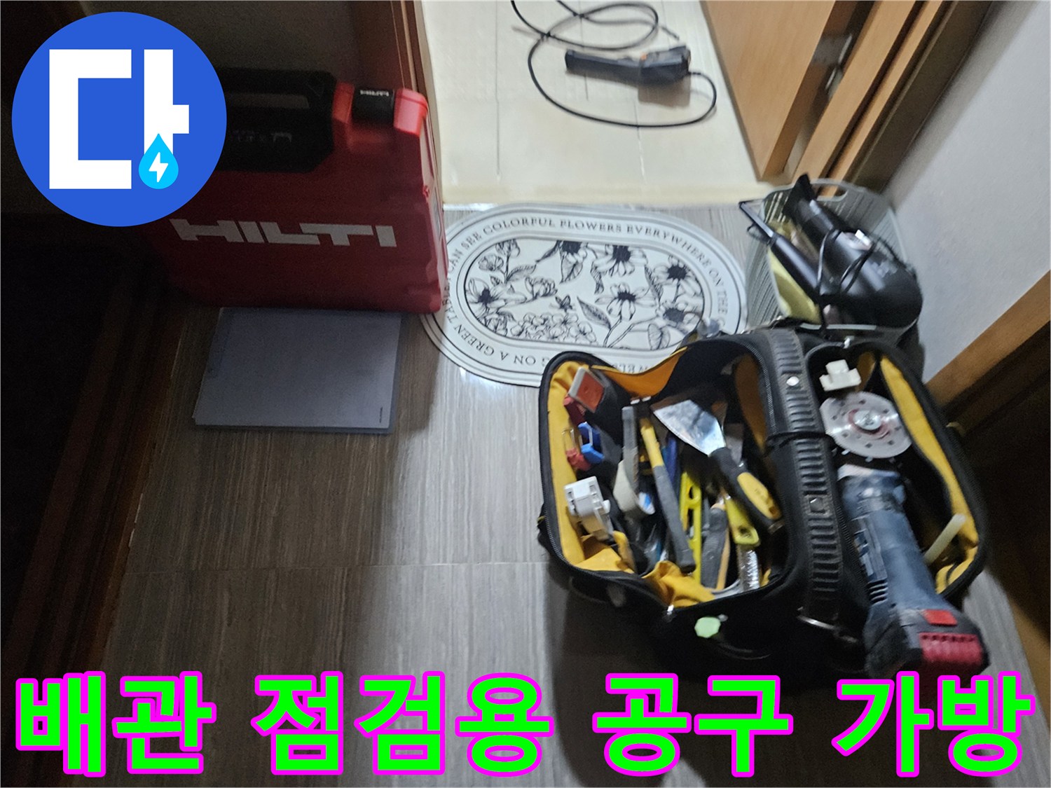 바닥에 놓인 배관 보수용 전문 장비와 공구들