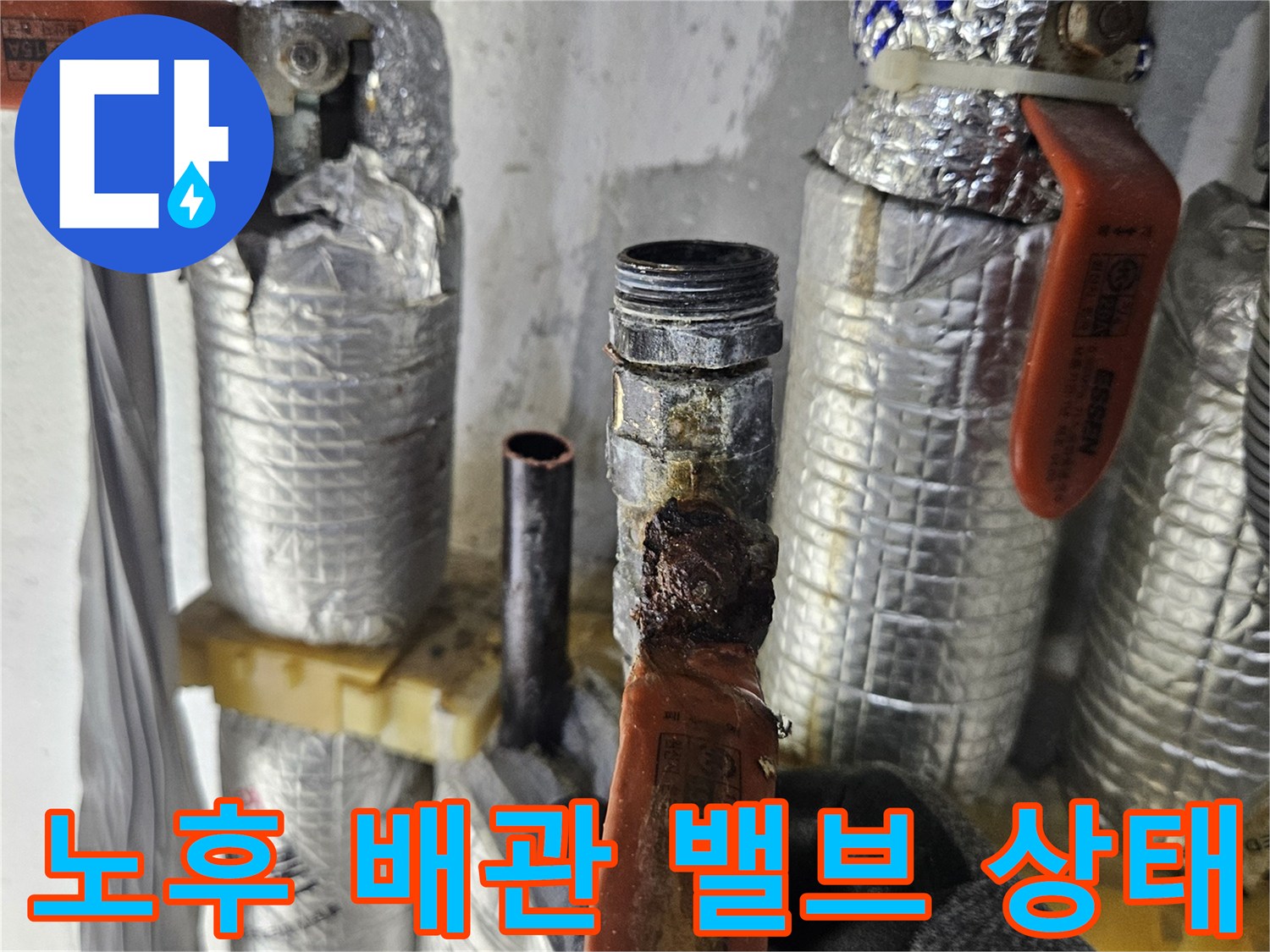 은박-보온재가-씌워진-배관의-주황색-밸브-연결부위-근접촬영