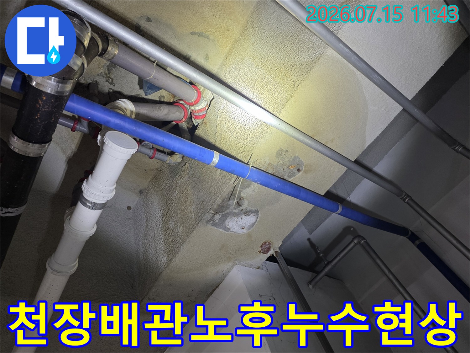천장에-설치된-흰색과-파란색-배관-및-콘크리트-면의-누수-얼룩