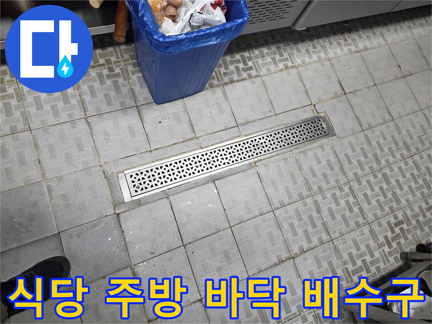 식당 내부의 스테인리스 배수 트렌치와 타일 마감 부위