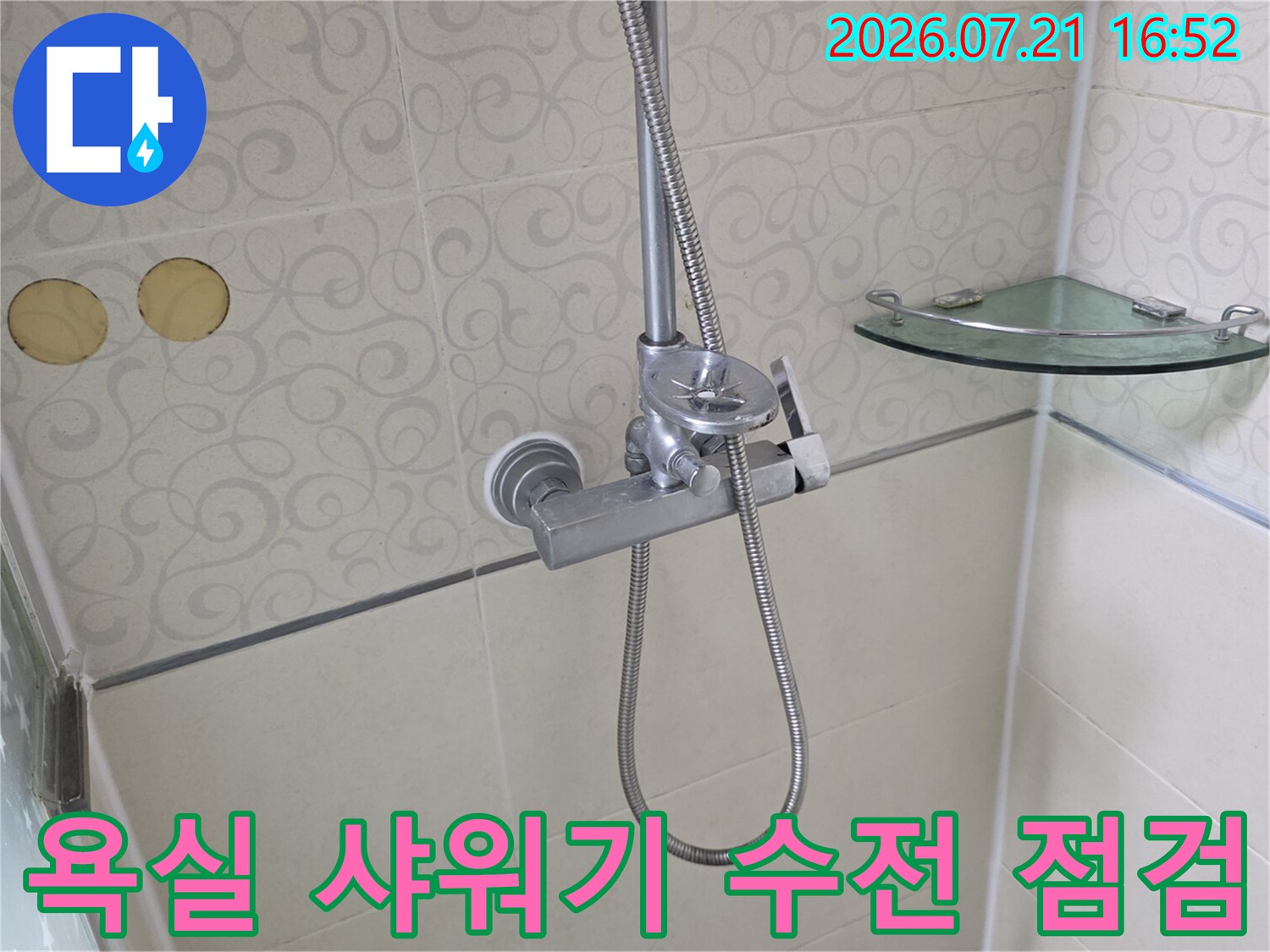 욕실 벽면에 설치된 수전과 호스의 모습