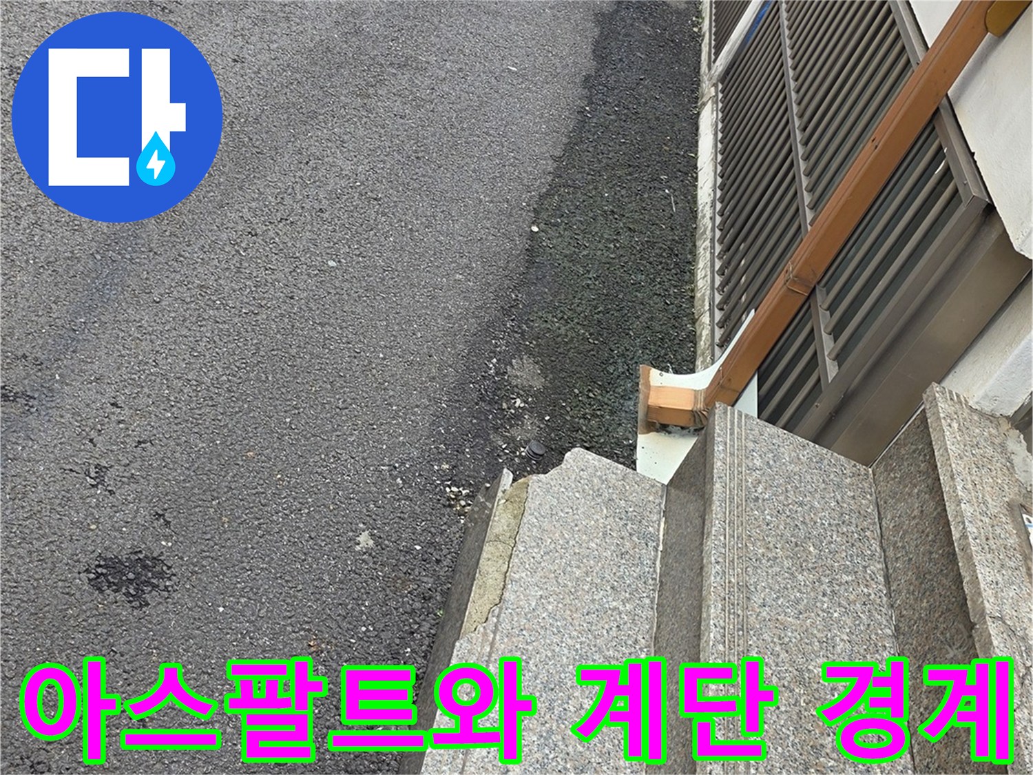 건물 입구 계단과 아스팔트 도로의 접합부