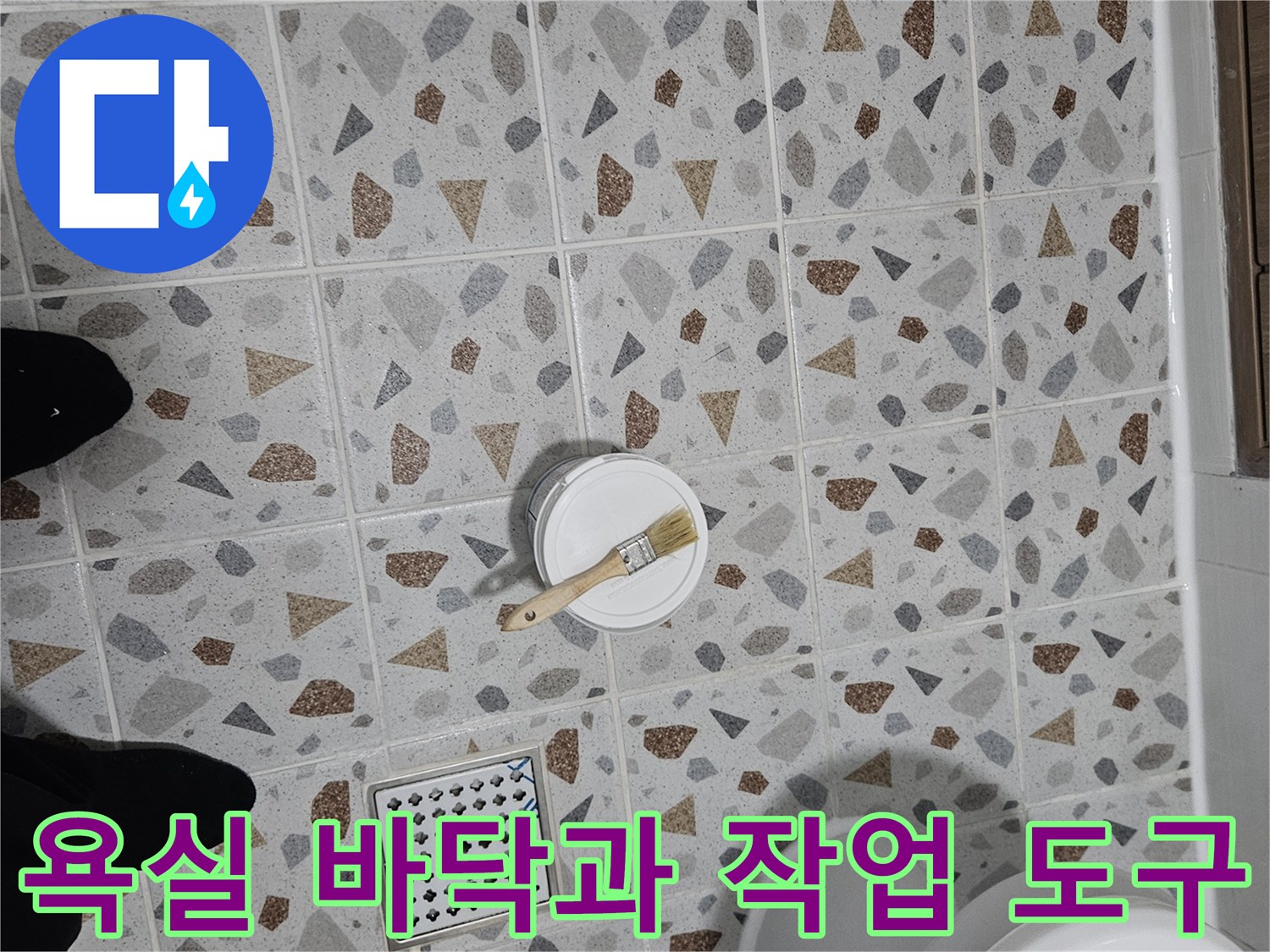 패턴 타일 위에 놓인 작은 통과 붓