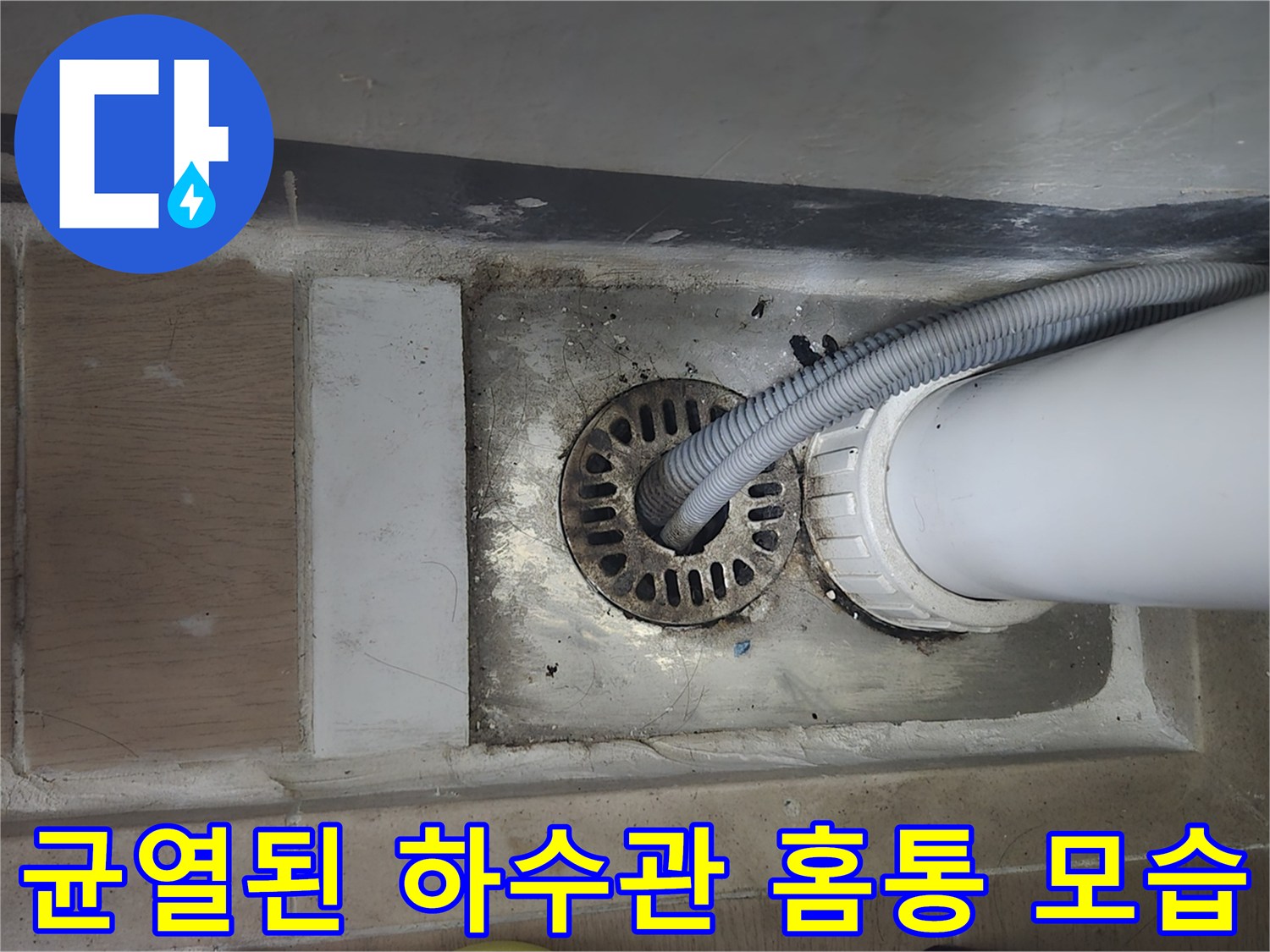 세탁실 바닥-깨진 배수관 홈통과 흰색 배관 연결부