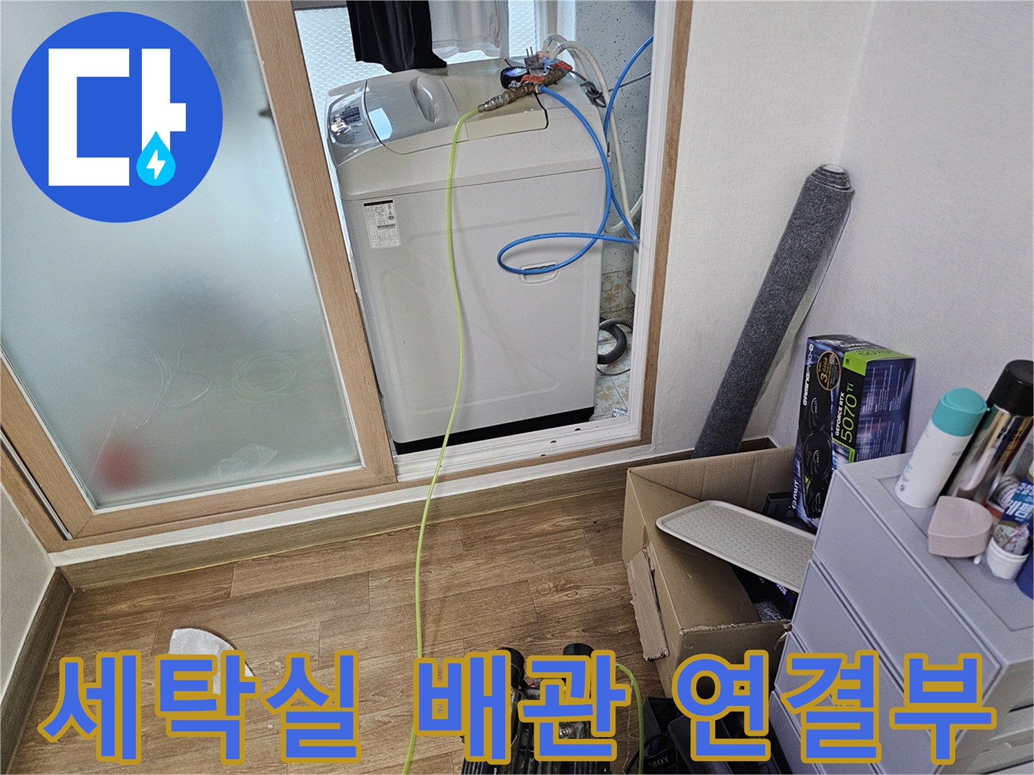 세탁기 뒤쪽의 파란색 호스와 노란색 선이 얽혀 있는 배관 모습
