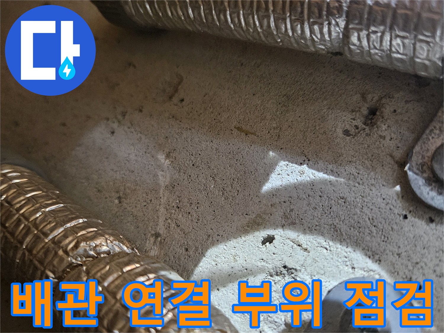 보온재로 덮여 있는 배관의 접합부와 고정 장치 모습입니다.