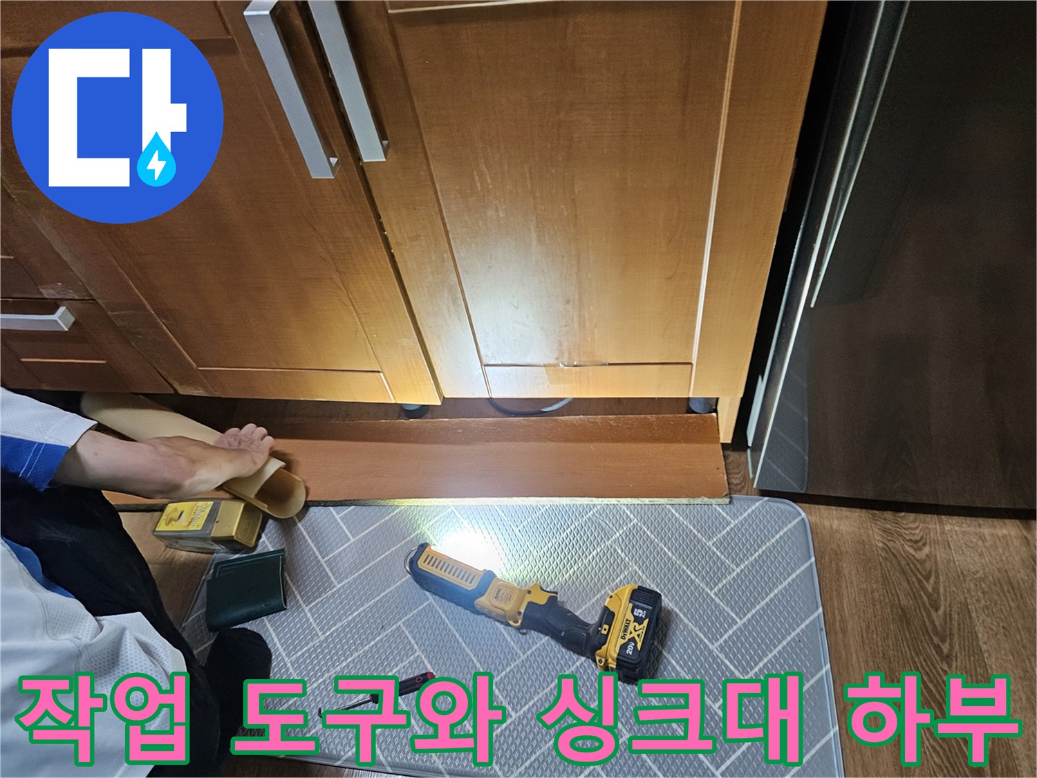 전동 드릴과 드라이버가 놓인 싱크대 하부 작업 현장