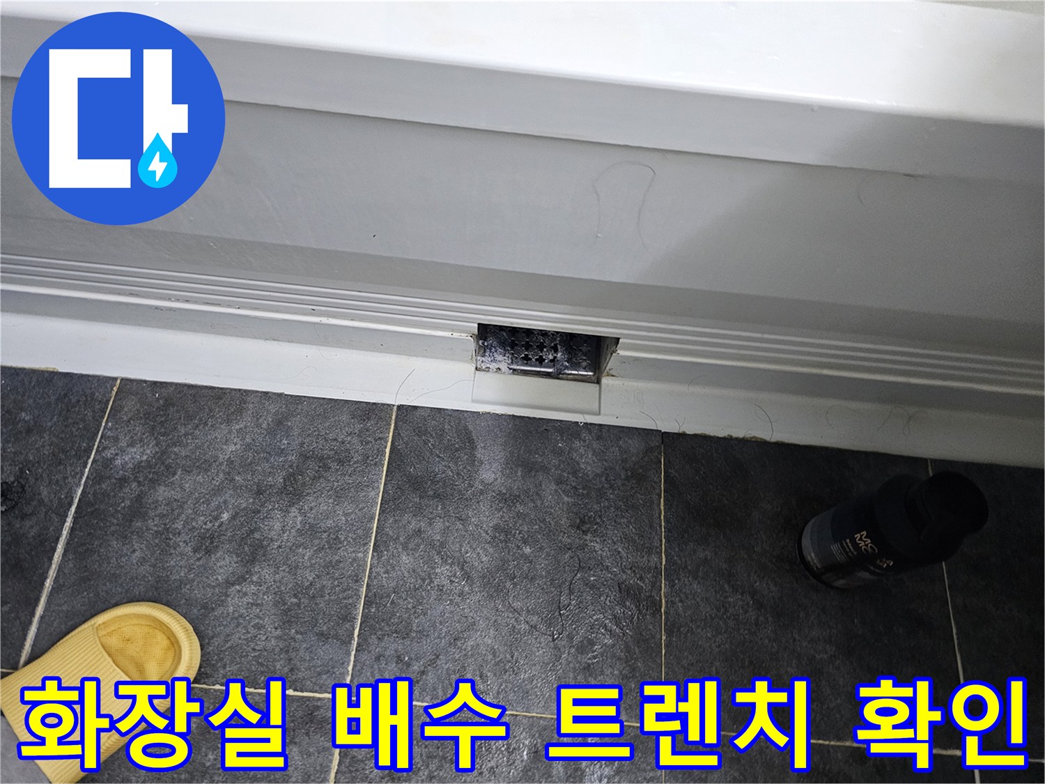 어두운 회색 타일과 흰색 배수구 덮개 부근