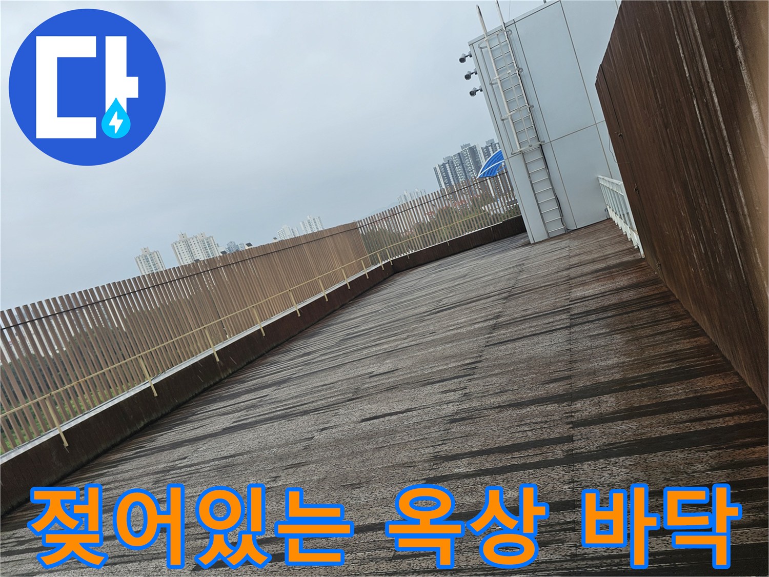 물기가 스며든 듯한 옥상 데크와 외벽 경계 부분