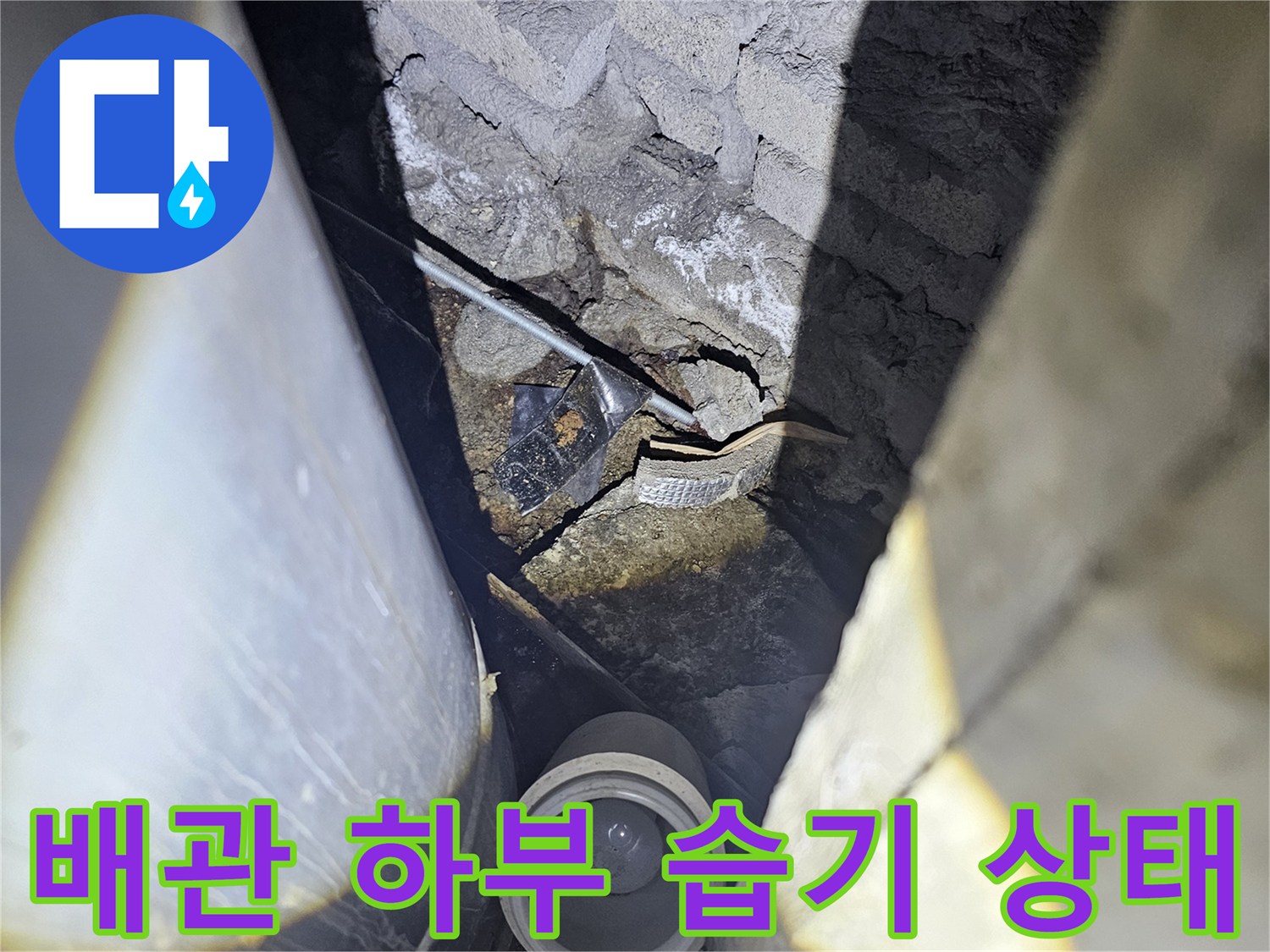 배관 관통 지점의 젖은 바닥과 균열 부위