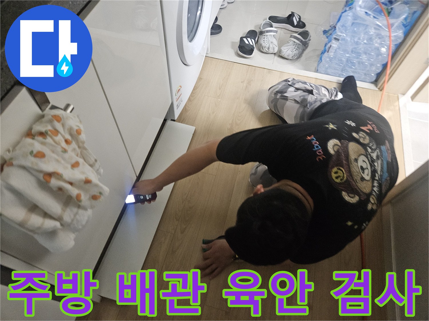 손전등-을-사용하여-싱크대-배관-틈새를-조사함