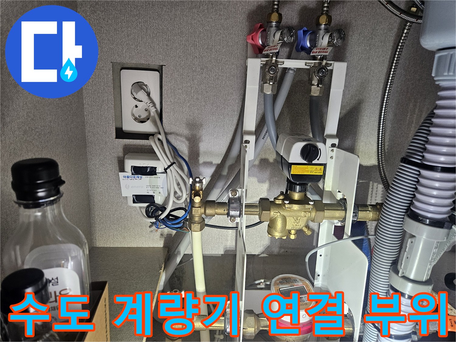 싱크대 하부장 내부에 설치된 수도 분기 밸브와 계량기 근처 배관