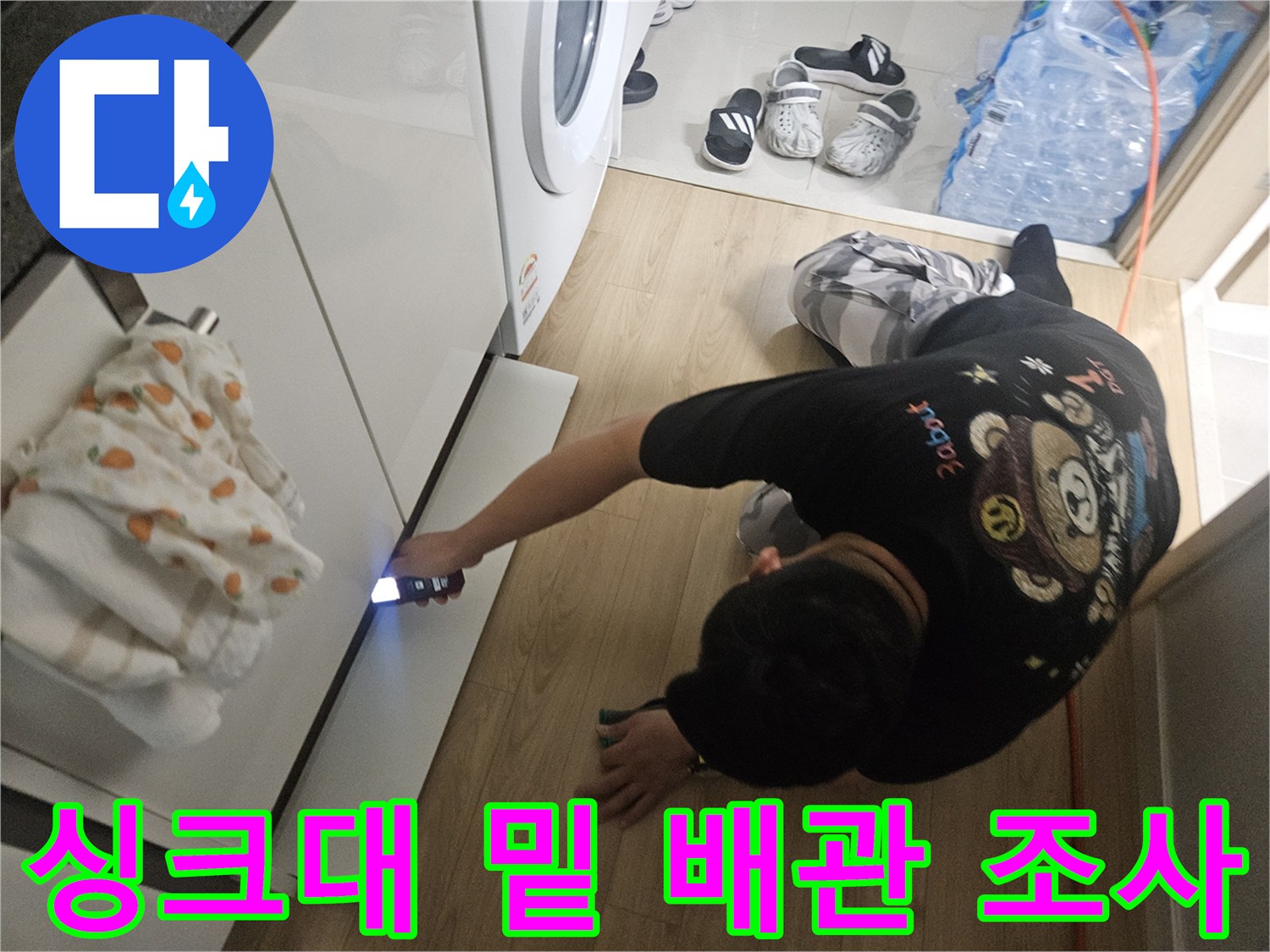 엔지니어가-손전등을-사용해-싱크대-하부-배관을-조사하는-모습