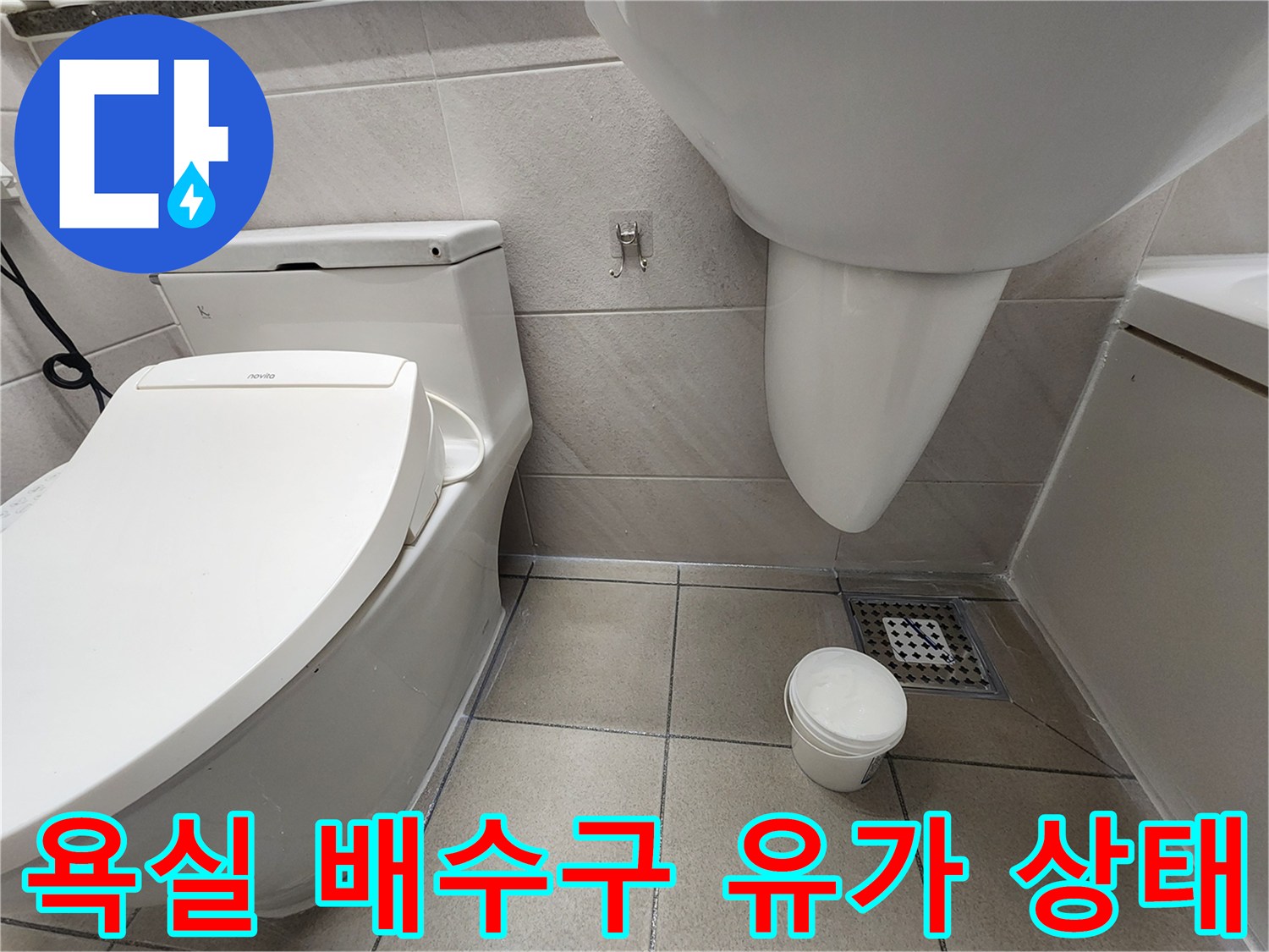 변기 옆 배수구 주변의 타일 마감 면 상세 사진