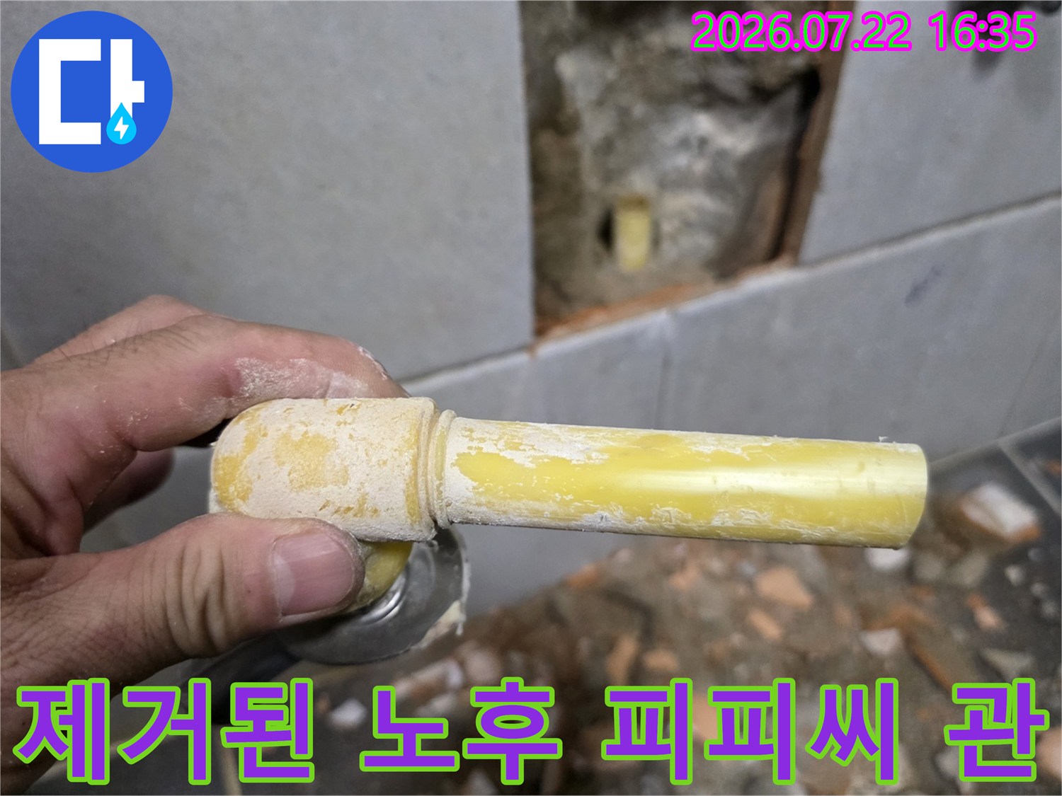 손에 쥐어진-노랗게 변색된-낡은 수도 배관 조각