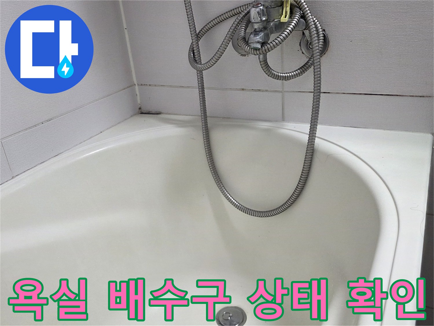하얀색 욕조 내부의 배수구와 샤워기 호스 모습
