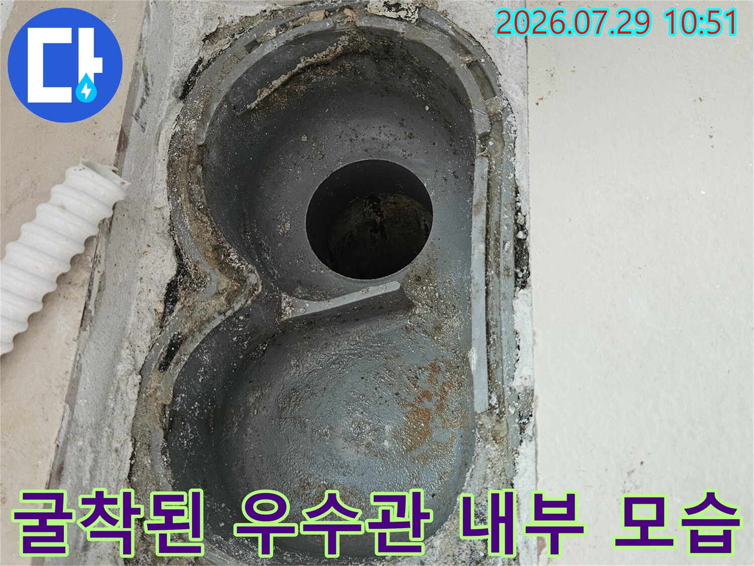 노출된 이중 구조의 배수관과 주변 콘크리트 파손 부위