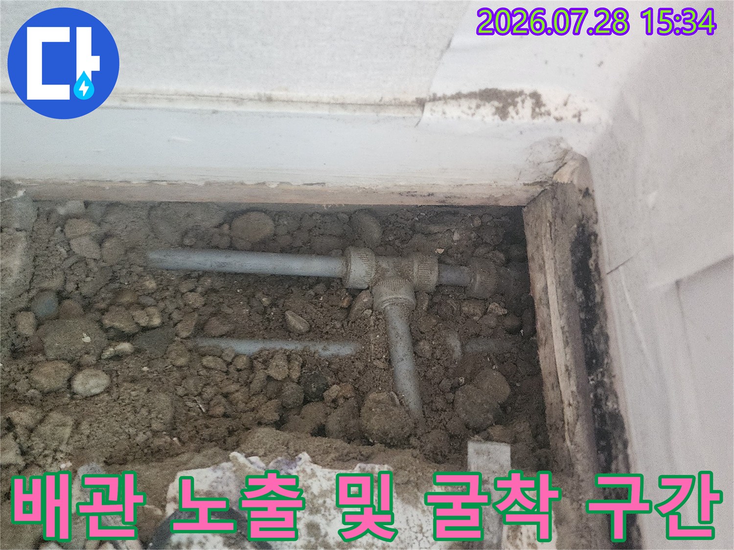 흙이 파헤쳐진 곳에 드러난 수도 배관 구성부