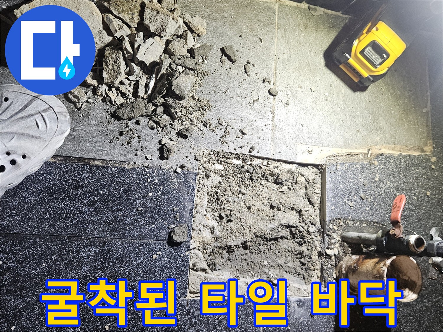 파손된 검은색 타일-드러난 콘크리트 층