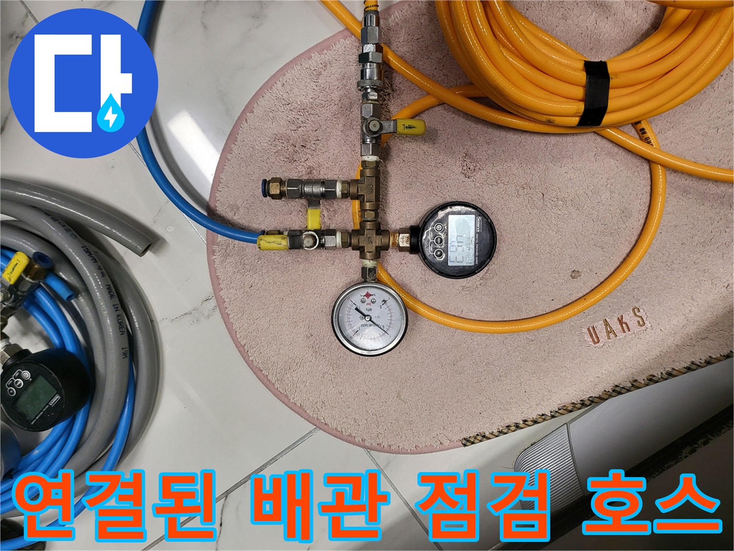 노란색과 파란색 고압 호스가 연결된 배관 진단 장비 세팅