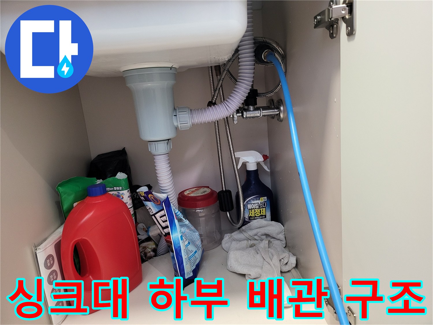 싱크대 아래쪽의 굴곡진 배수 호스와 급수 라인 연결