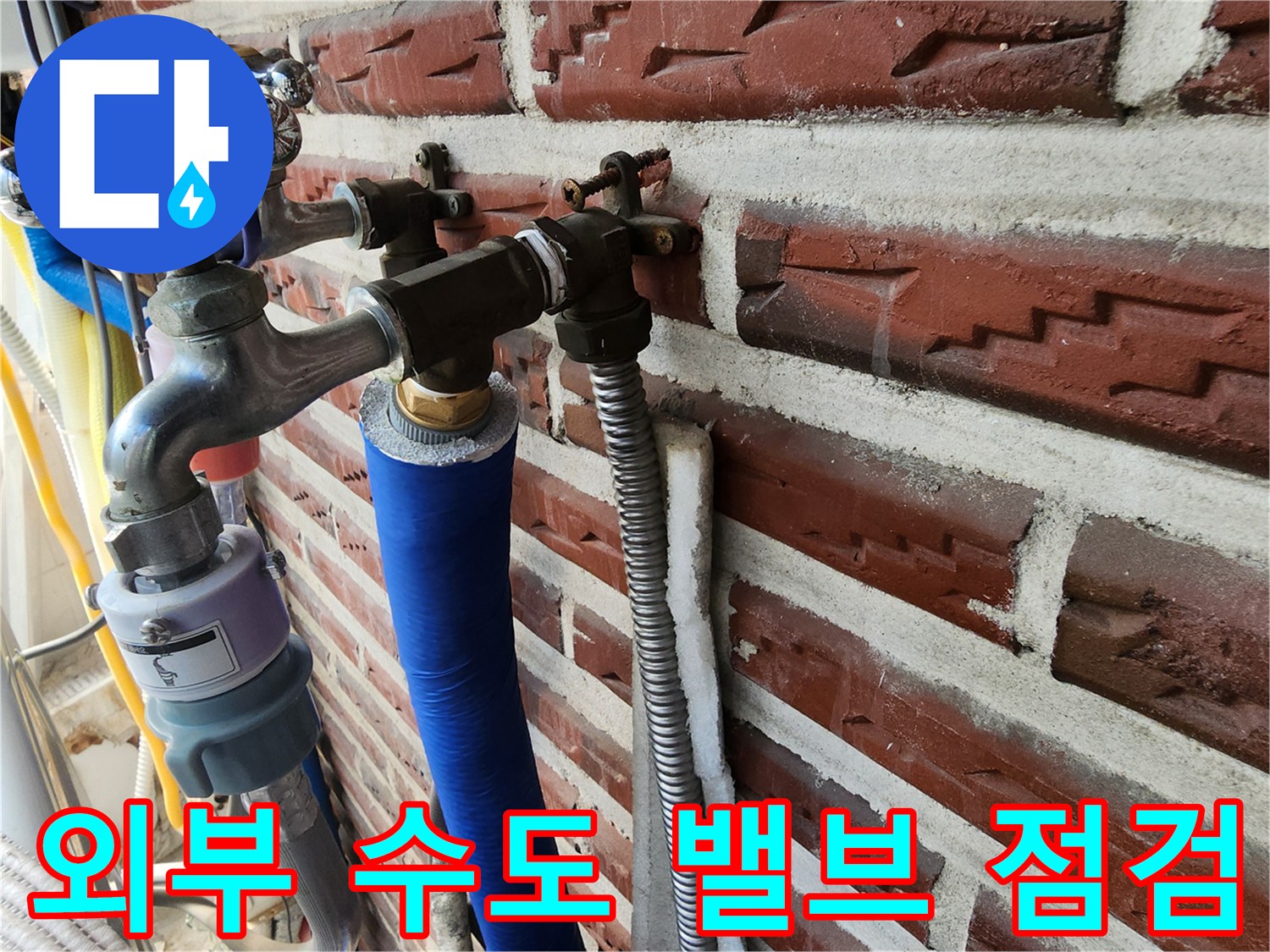 벽돌 벽면에-고정된 금속 소재의 수도 밸브와 연결 배관