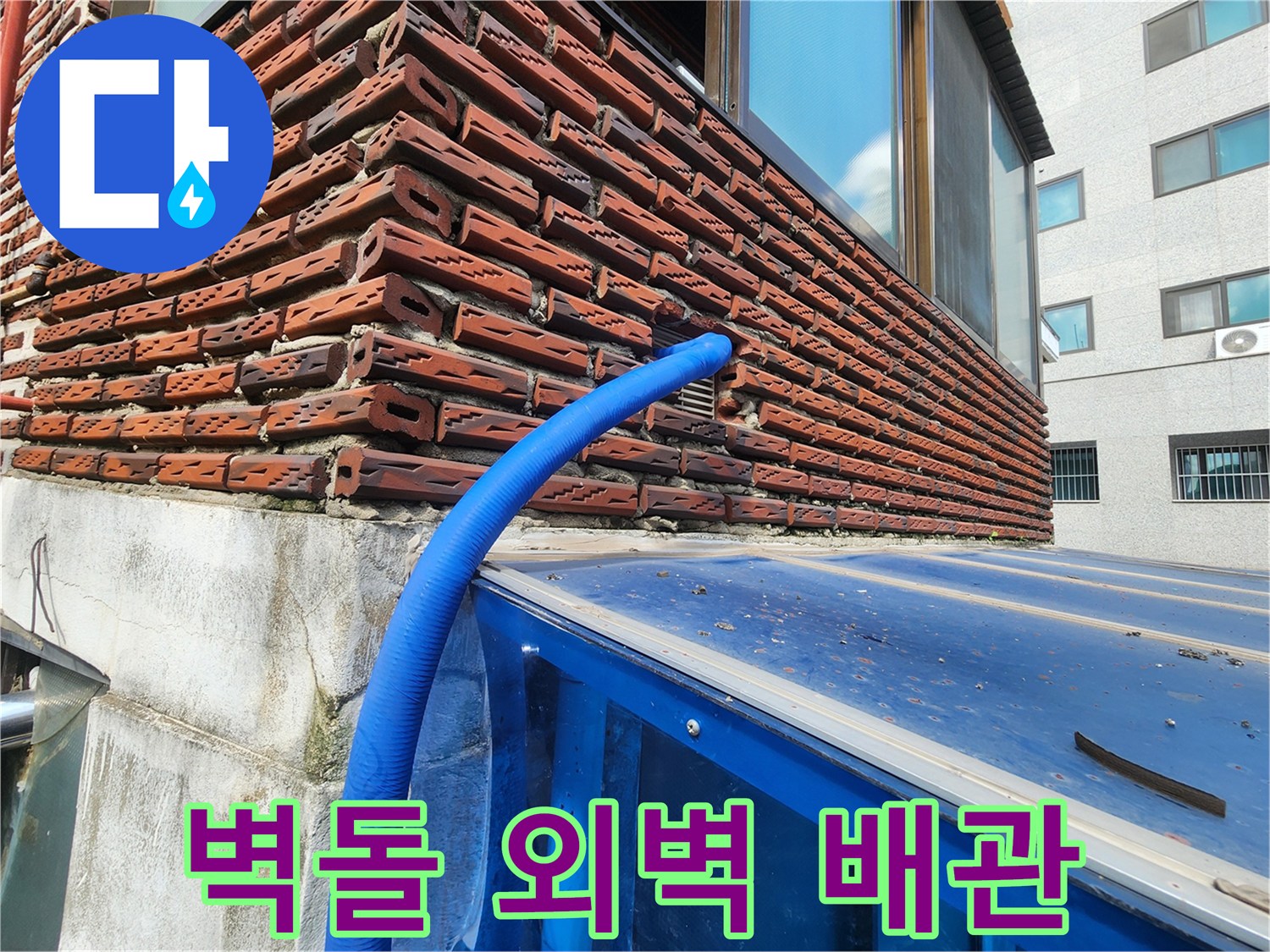붉은 벽돌 구조물과 파란색 보온재가 씌워진 배관의 연결 부위