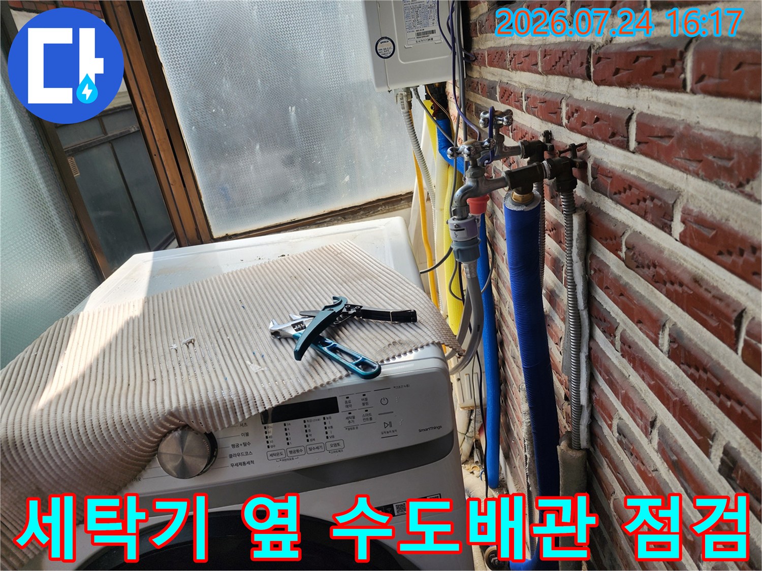 세탁기 위 노출된 파란색 보온재 배관과 밸브 연결부 점검 모습
