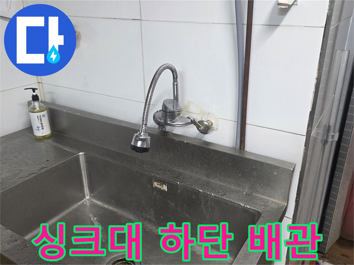 싱크대 하단부의 수전 및 벽면 연결 부위 모습