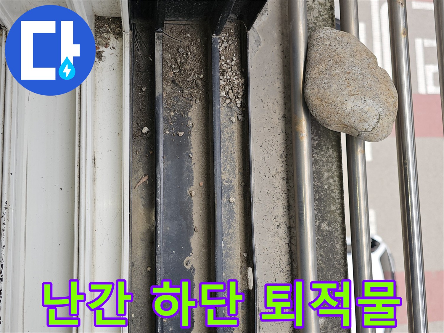 난간 구조물 사이에 쌓여 있는 흙과 돌멩이