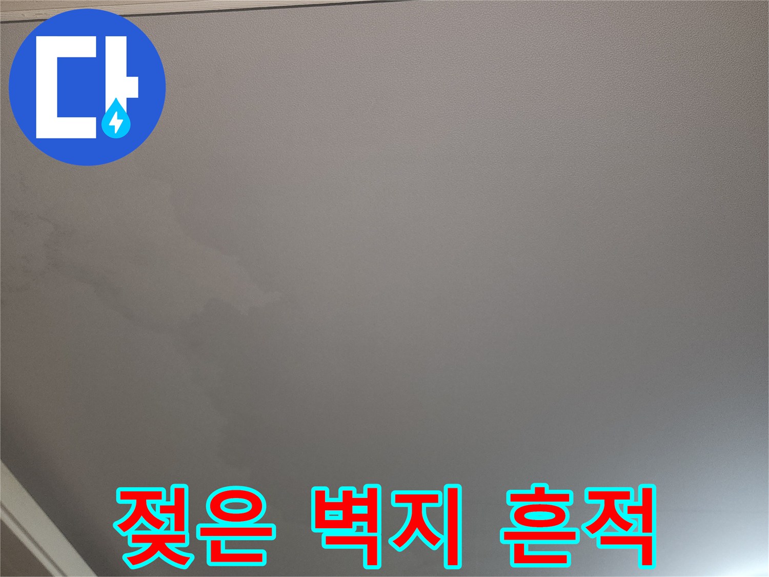 벽지가 물에 젖어 어둡게 변한 천장 부분의 상세 사진입니다.