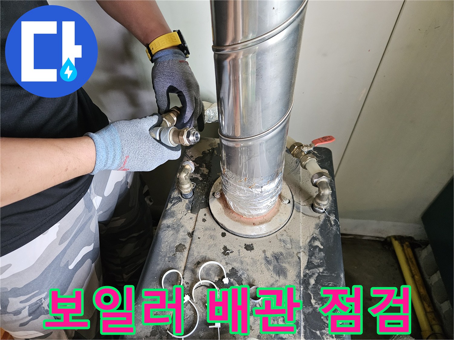 장갑을 낀 작업자가 보일러 하단 배관을 만져보는 사진