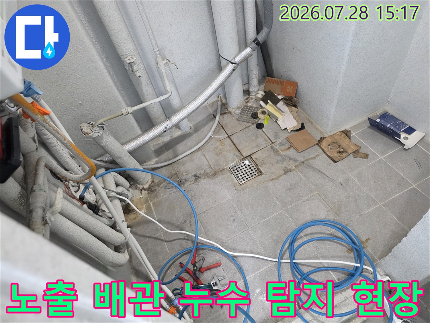 보온재가 씌워진 여러 가닥의 수도 배관과 파란색 호스 연결부