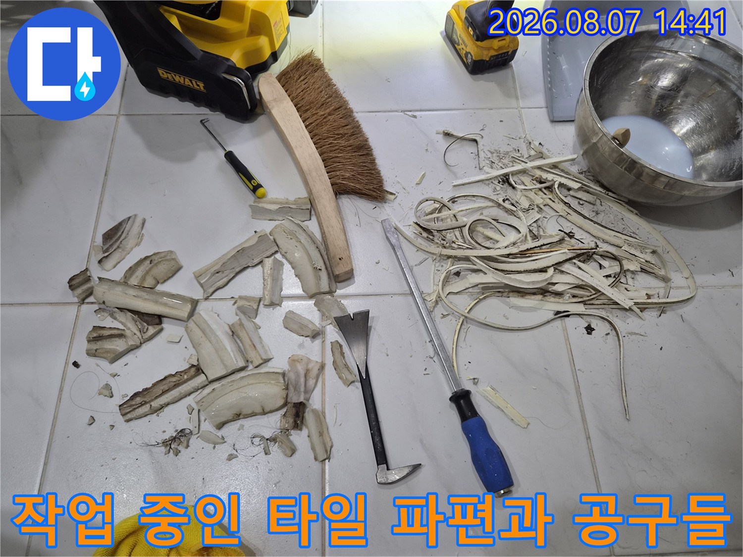 탈거된 타일 조각들과 작업용 브러쉬 및 수공구 세트