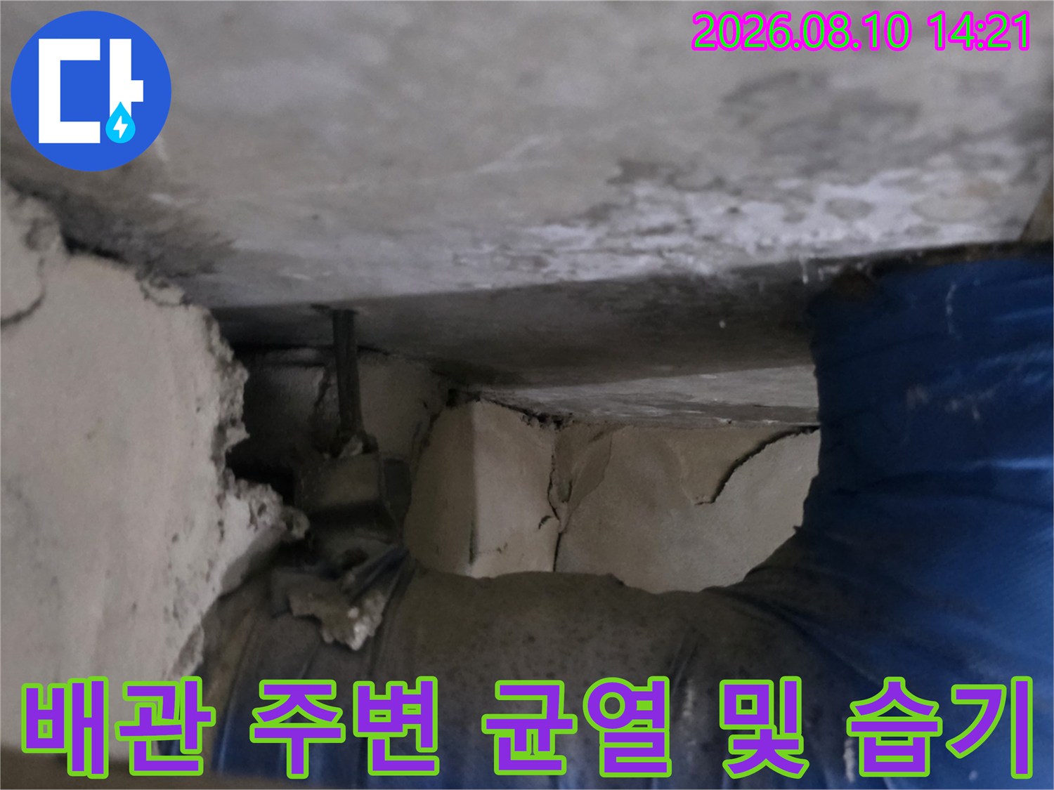파란색 배관과 갈라진 천장 마감재의 누수 흔적