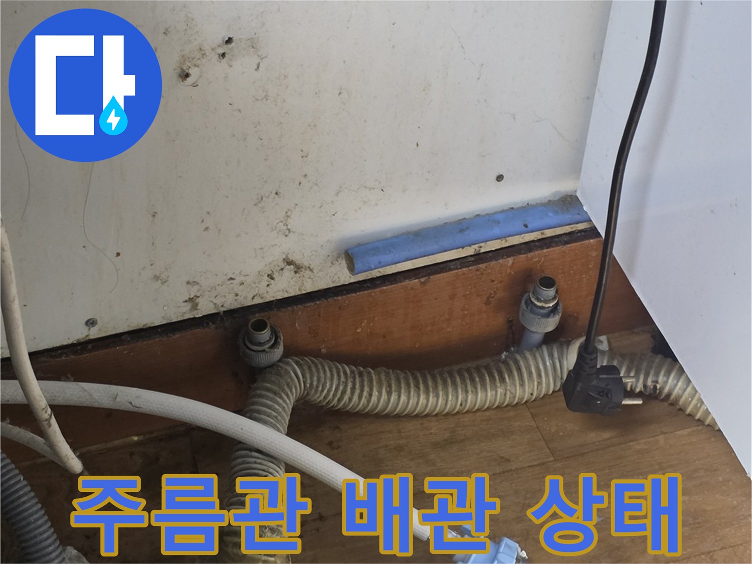 싱크대 하단 가림막을 제거하고 드러난 노후된 주름관과 연결 호스들