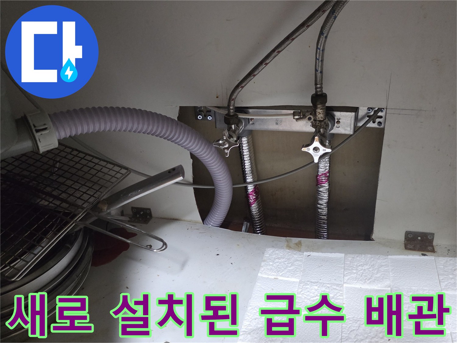 싱크대 하부장 내부의 정리된 배관 및 밸브 연결 부위
