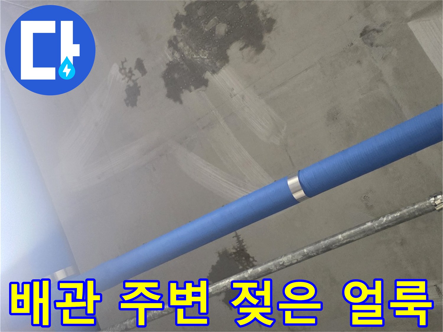 파란색 배관 옆으로 넓게 퍼진 천장 누수 자국