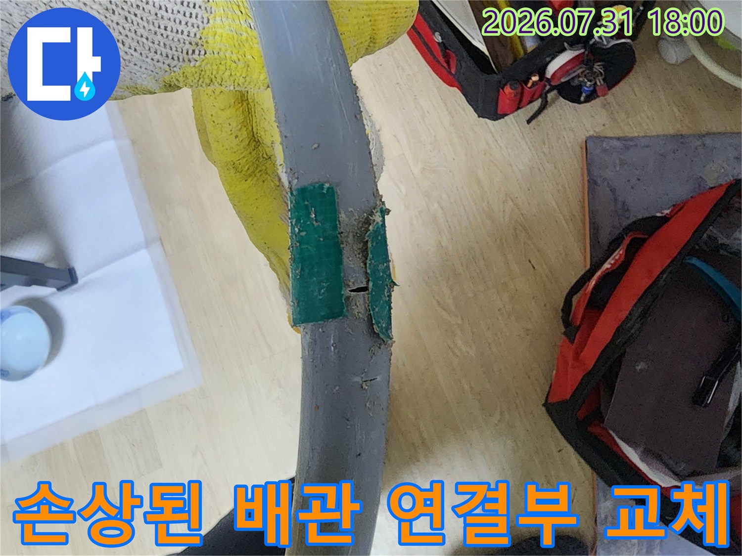 파손된 회색 배관을 새 자재로 보수한 장면
