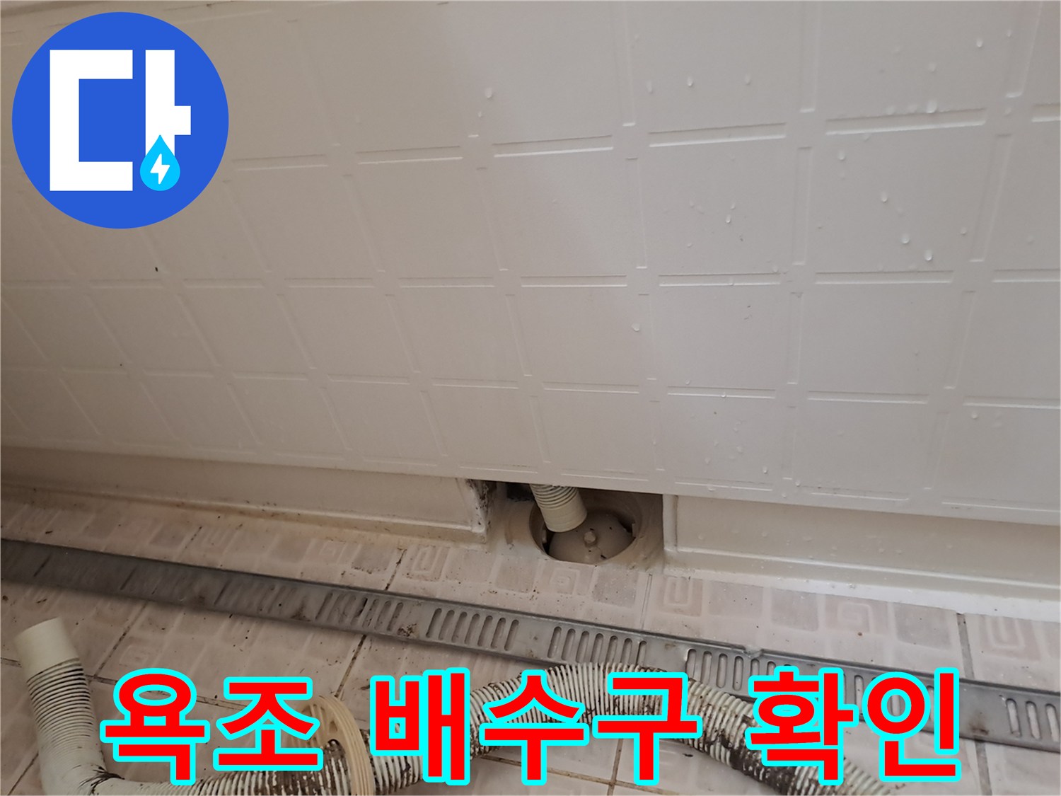 타공된 점검구를 통해 보이는 욕조 하부 배관 연결 상태
