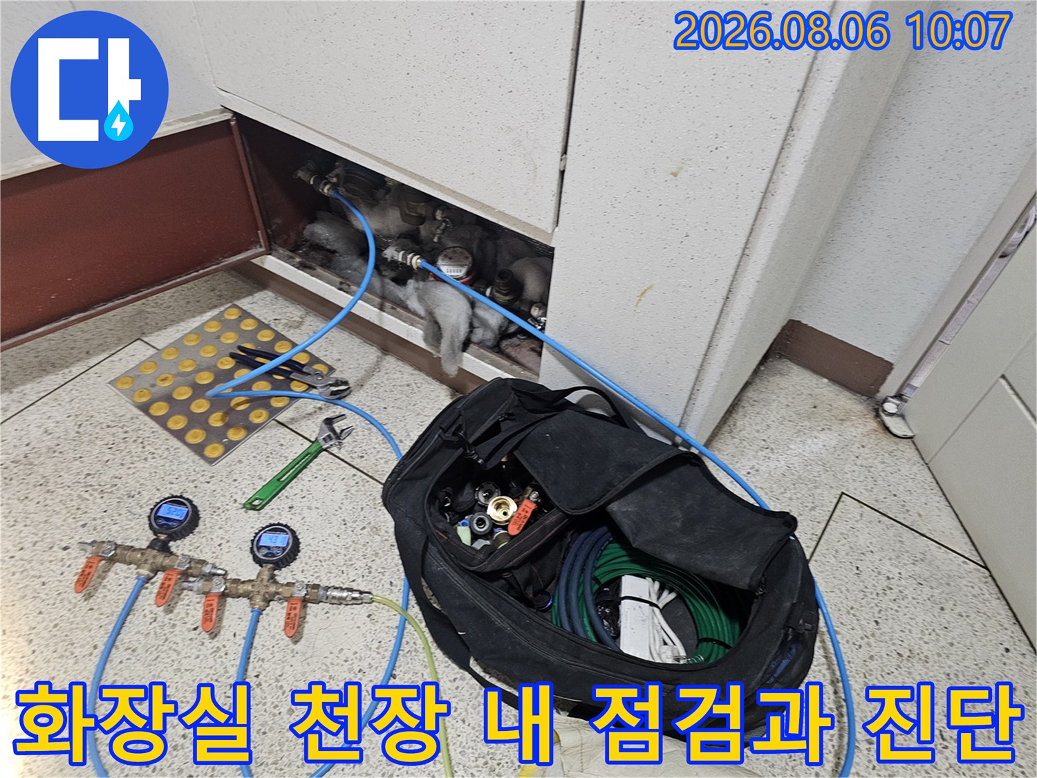 배관 테스트용 장비와 파란색 호스가 연결된 천장 내부 모습