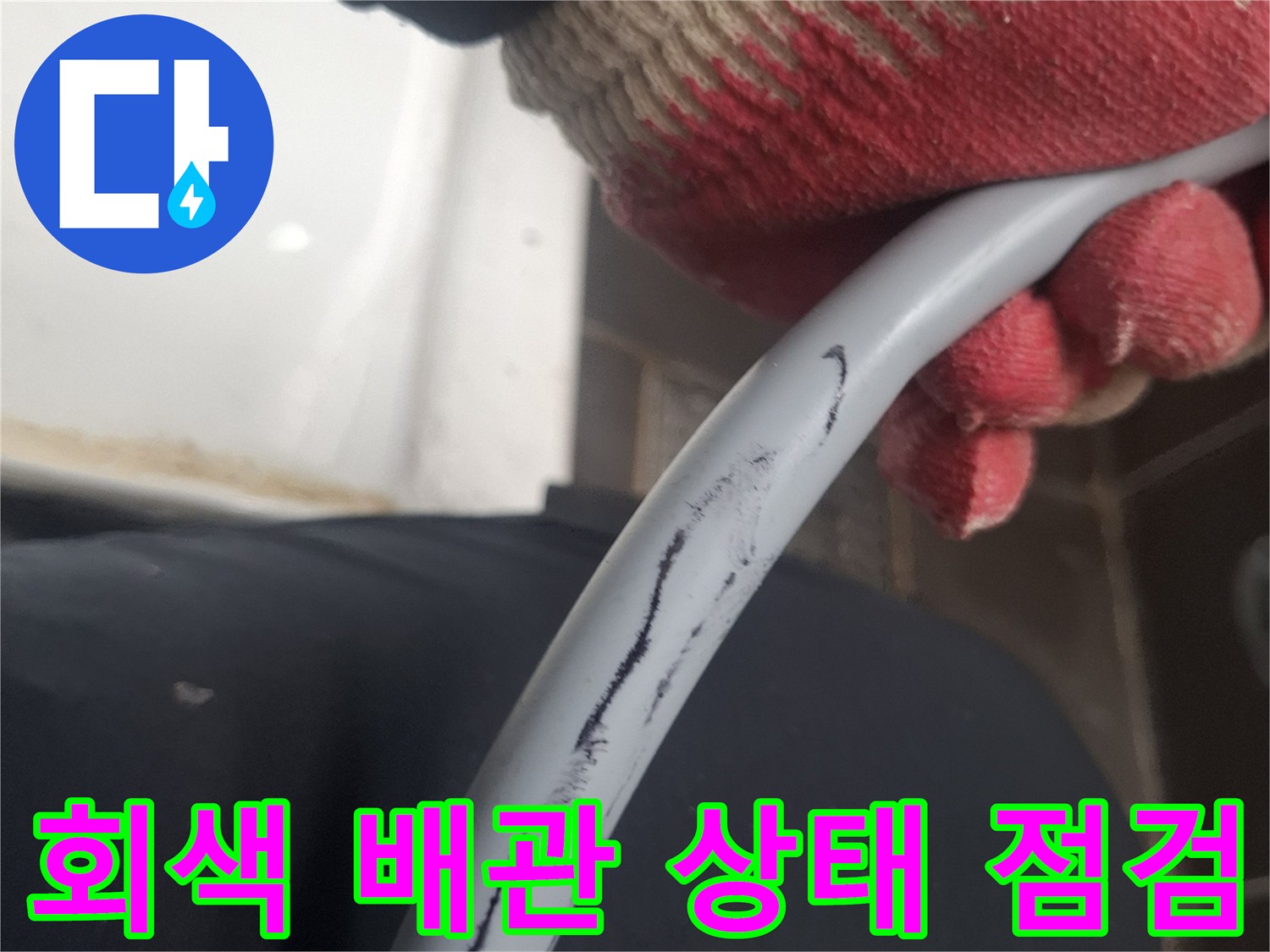 장갑을 착용한 손으로 잡고 있는 배관 부위
