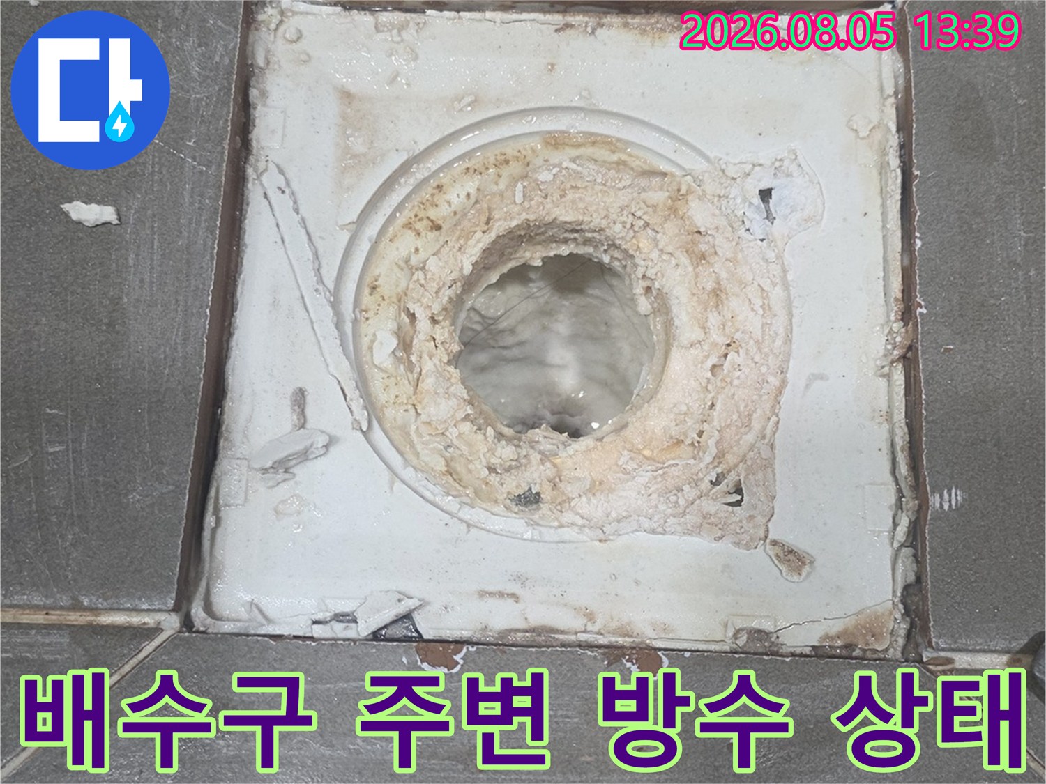 노후된 배수구 유가 주변의 파손된 시멘트와 마감층을 찍은 사진입니다.