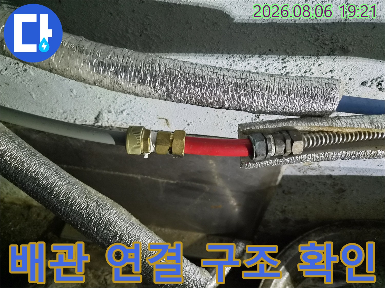 금속 밸브와 빨간 호스가 결합된 배관의 근접 촬영 사진