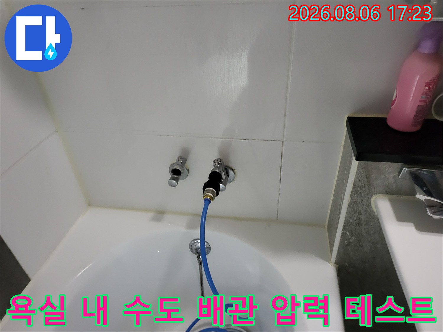 파란색 호스로 연결된 수도 배관의 기밀성 검사 과정