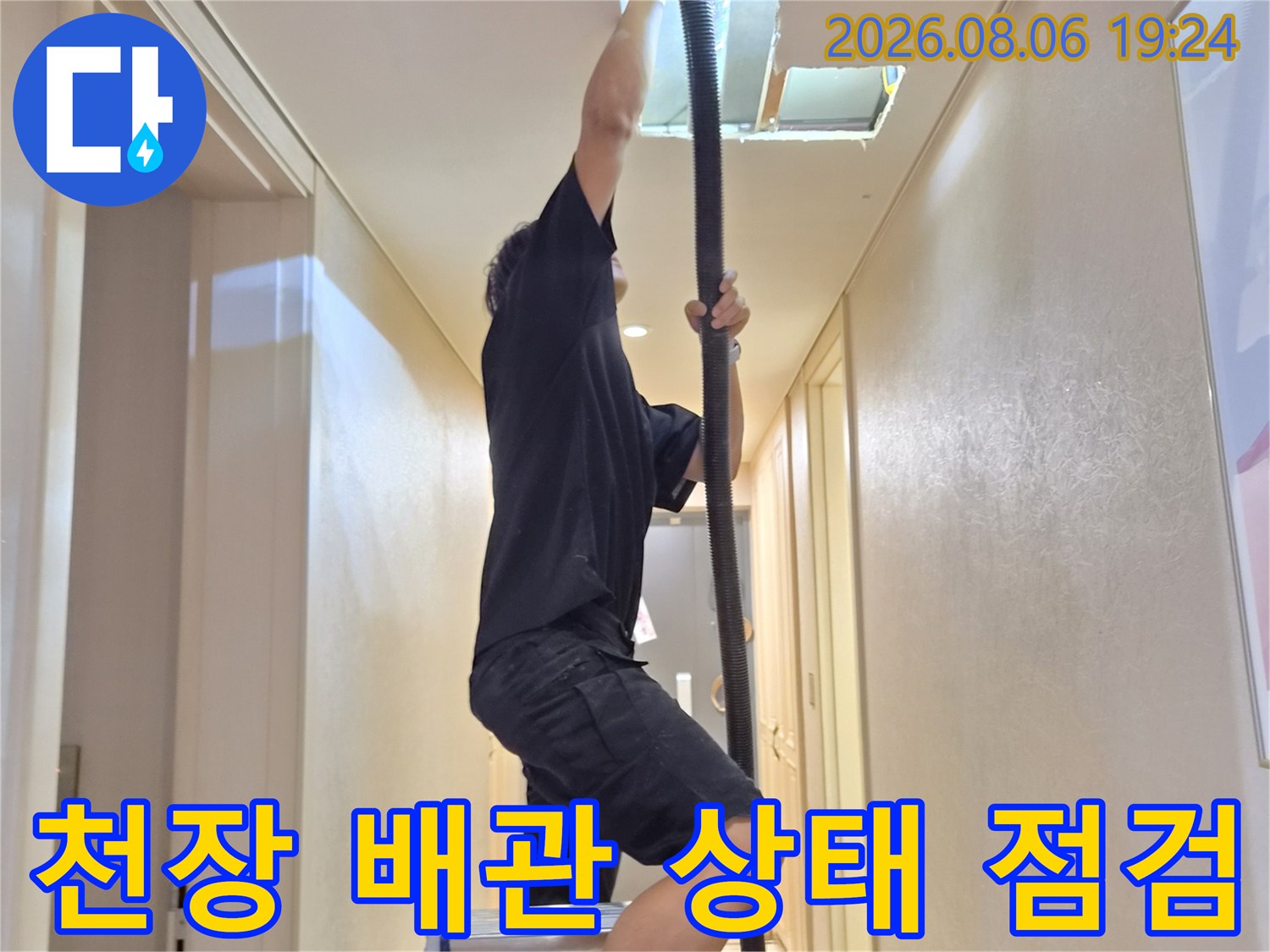 사다리 위에서 천장 안쪽 에어컨 배관을 살펴보는 엔지니어